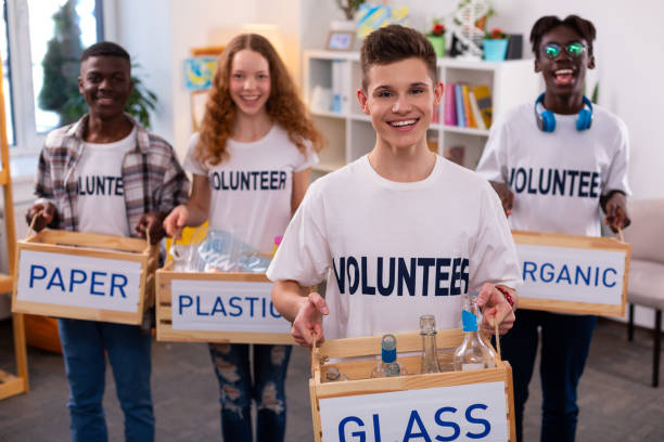 istock Handsome teenager holding box with glass bottles after sorting 1148048171