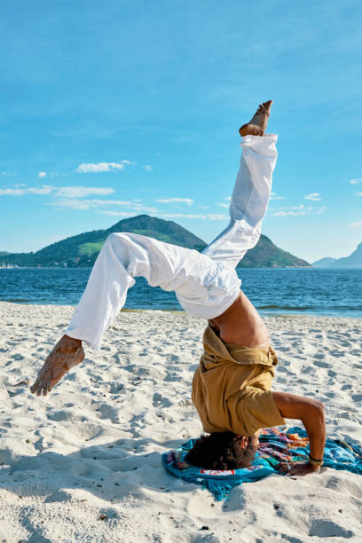 istock man doing yoga on the beach 1148048289