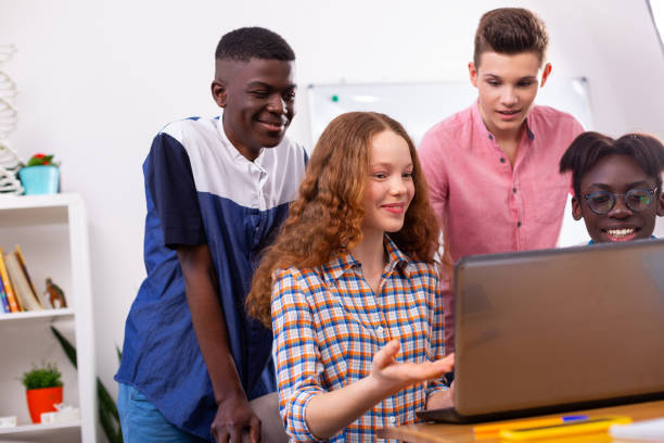 istock Girl watching online lesson with boys while studying together 1148048890