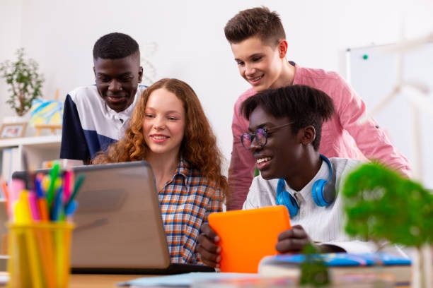 istock Company of teenagers using laptop and tablet while studying together 1148048903