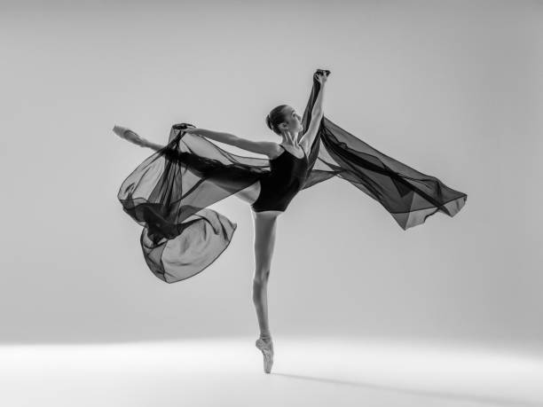 junge schöne tänzerin tanzt auf grauem hintergrund - ballet dancer beautiful dancing beauty stock-fotos und bilder