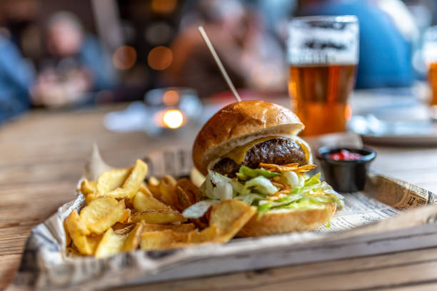 un hamburger con patatine fritte sul lato e una birra artigianale - refreshment dinner table vegetable foto e immagini stock