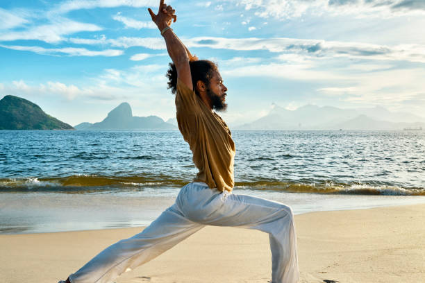istock man doing yoga on the beach 1148049239
