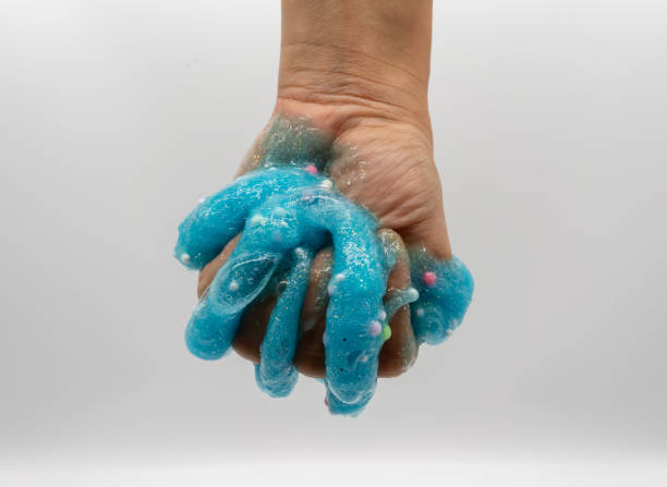 istock Hand playing transparent blue glitter slime isolated on white background 1148052560