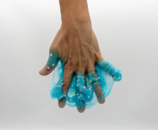 istock Hand playing or soaking transparent blue glitter slime isolated on white background 1148052562