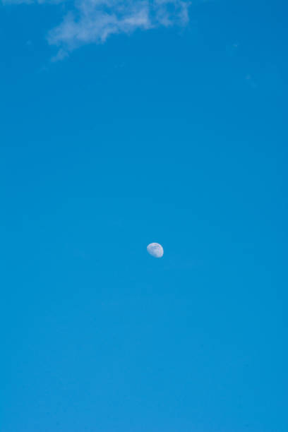 A beautiful moon on a daytime blue, magical sky with white clouds 2019