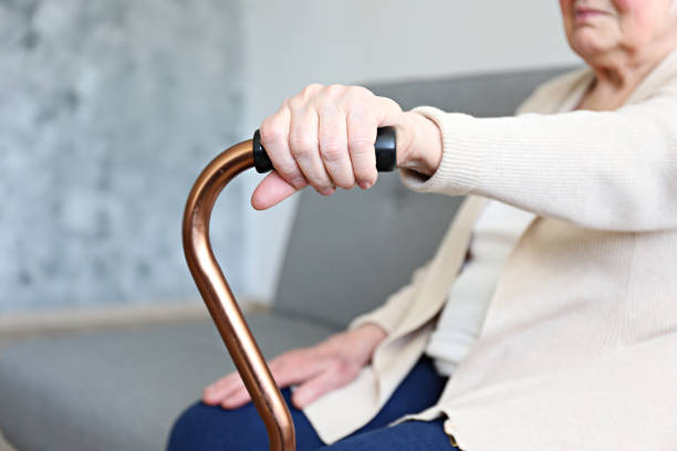 istock Old age woman with health problems resting her arms on walking cane. 1148057125