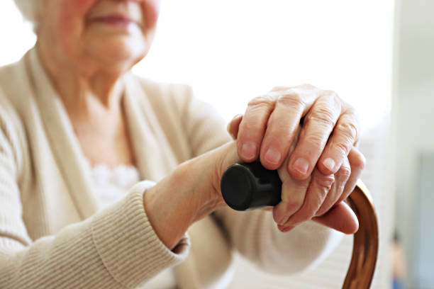 istock Old age woman with health problems resting her arms on walking cane. 1148057157