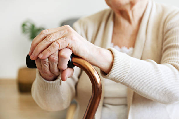istock Old age woman with health problems resting her arms on walking cane. 1148057170