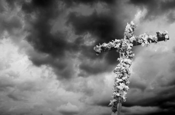 istock Easter Cross decorated with flowers against a dramatic sky captured in black and white 1148062033