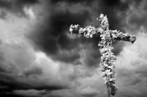 istock Easter Cross decorated with flowers against a dramatic sky captured in black and white 1148062034