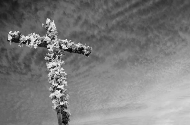 istock Easter Cross decorated with flowers against a dramatic sky captured in black and white 1148062035