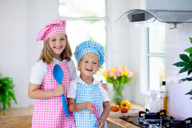 istock Kids cook in white kitchen. Children cooking. 1148066250