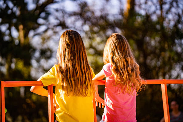 Back view girls sitting at playground