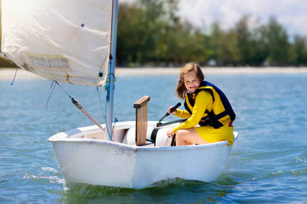 Child sailing. Kid learning to sail on sea yacht. Healthy water sport for school kids. Yachting class for young sailor. Children on boat. Family summer vacation on tropical island. Beach activity.