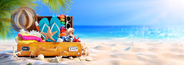 istock Full Suitcase With Accessories On Tropical Beach 1148071319