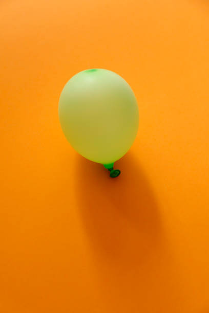 istock Green Balloon on orange background 1148078718
