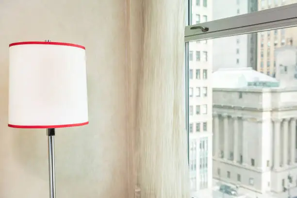 Photo of Retro red and white color lamp by window view looking at midtown New York City NYC cityscape skyline in Manhattan hotel apartment condo high rise building