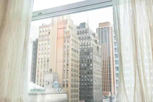 Photo of New York City, USA urban cityscape building skyscrapers in NYC Herald Square vintage view through window and curtains