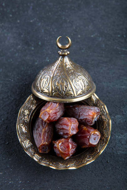 istock Dates fruit (hurma) in a bowl close up on wooden background. 1148080019