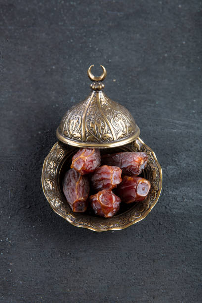 istock Dates fruit (hurma) in a bowl close up on wooden background. 1148085983