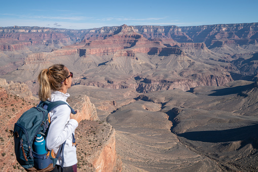 Young woman travels in USA and contemplates the famous Grand Canyon, United States, people travel explore nature