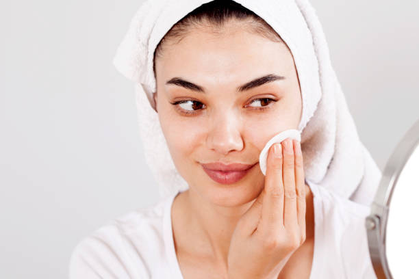 istock Beautiful brunette woman removing makeup from her face 1148095514