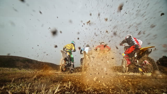 SLO MO Motocross racers taking off and bursting gravel