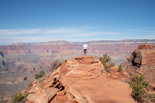 Young woman travels in USA and contemplates the famous Grand Canyon, United States, people travel explore nature