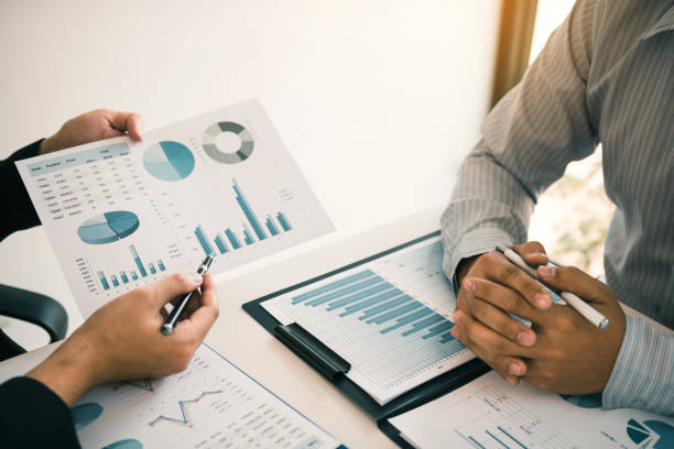 istock Two business partnership coworkers analysis strategy and gesturing with discussing a financial planning graph and company budget during a budget meeting in office room. 1148113835