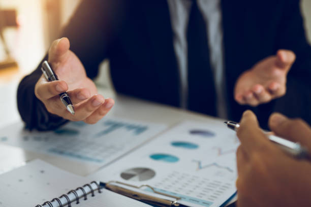 istock Two business partnership coworkers analysis cost work progress and gesturing with discussing a financial planning graph and company financial during a budget meeting in office room. 1148113939