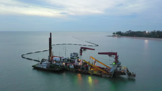Aerial view of a hopper dredge collecting sand from the bottom of the ocean during a beach replenishment project