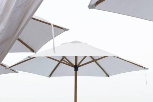 istock Summer day at the beach with white umbrellas. 1148116033