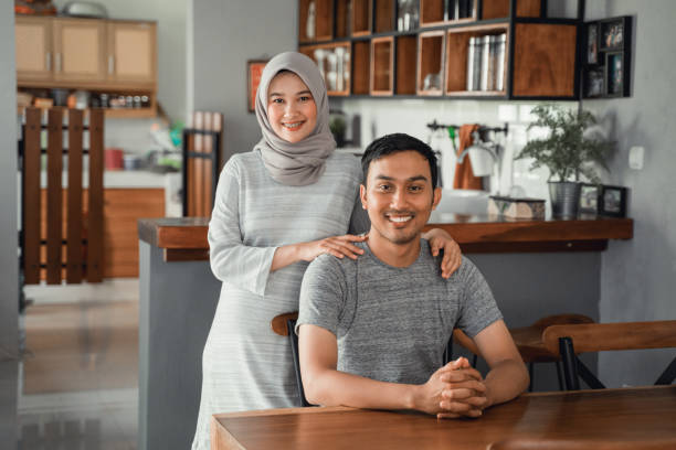 muslim couple sitting in dining room together portrait of muslim couple sitting in dining room together hijab photos stock pictures, royalty-free photos & images