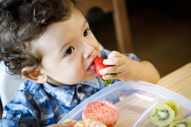 istock Baby boy tasting strawberry 1148119024