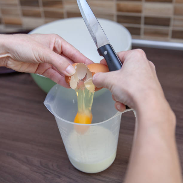 istock woman preparing cake from flour and eggs. He breaks the egg and separates the egg white from the yolks 1148122050