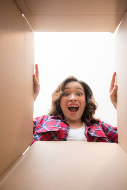 istock woman looking down at camera through cardboard box 1148126136