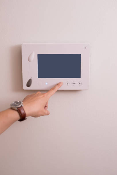 istock People push button on door phone to watch home security system 1148127166