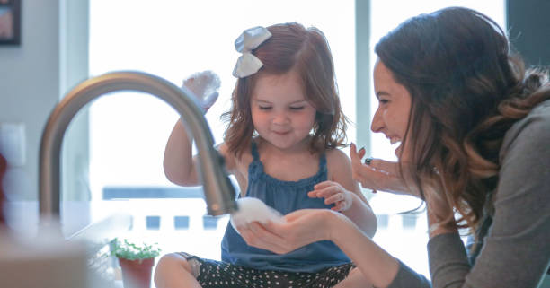 istock Mother and daughter play in soap suds 1148128400