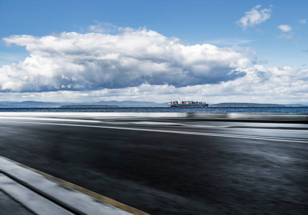 blurred motion coastal road with a container ship in the background,usa.