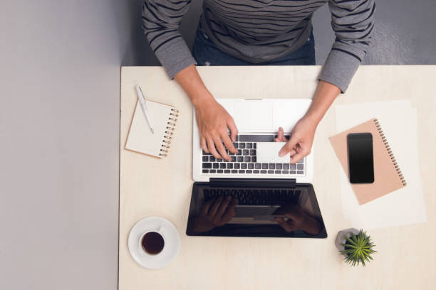 istock Man working at office desk with a laptop and shopping online, he is using a credit card, e-commerce and electronic payments concept - Image 1148129361
