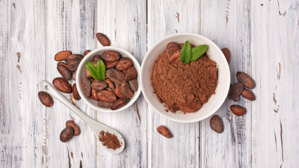 istock Top view on cocoa beans and powder in bowls 1148132764