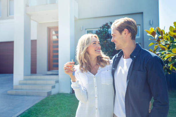 young couple holding their new house key. - garden key imagens e fotografias de stock