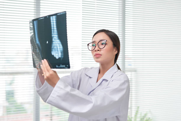 istock Woman in scrubs examining X-rays 1148134314