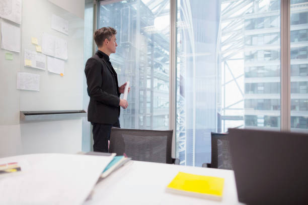 istock Man standing in office and looking out of window 1148138194