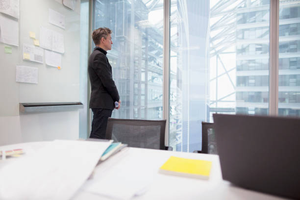 istock Man standing in office and looking out of window 1148138208