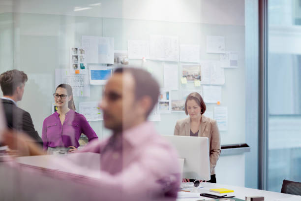 istock Colleagues working behind glass wall meeting room 1148138569