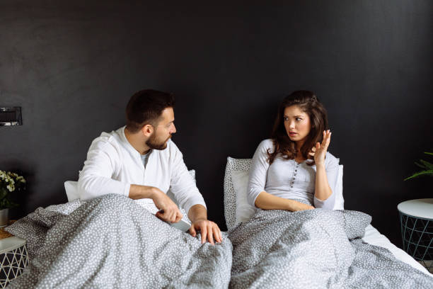 istock Man neglecting his girlfriend and using his mobile phone in bed 1148139768
