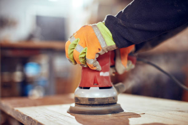 istock Carpenter using orbital electric sander in a retro vintage workshop. 1148142250