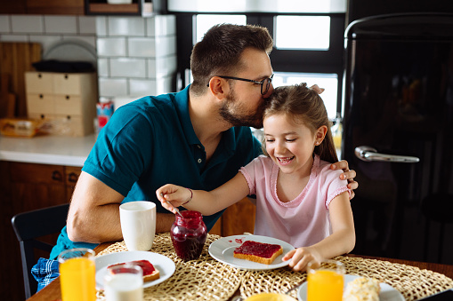 Father and daughter having breakfast at home